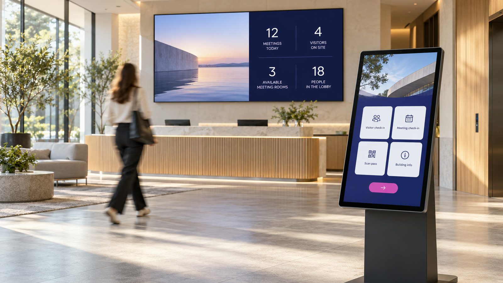 A bright reception lobby with a touch kiosk in the foreground and a large wall screen showing live numbers
